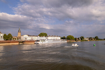 Pleasure boat passing by on River IJssel with countenance of Hanseatic tower town Zutphen in the...