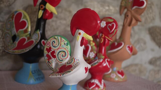 Hand painted Barcelos rooster figurines with vibrant heart motifs, embodying Portuguese folklore