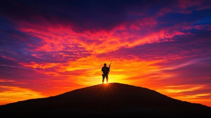 A silhouette of a soldier standing on a hill during a dramatic sunset The sky is filled with vibrant hues of orange