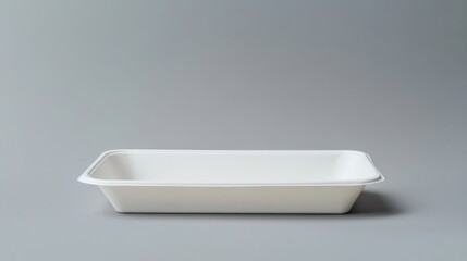 Fototapeta premium A blank tray sits on a grey background, providing a perfect mockup for showcasing product designs or creative presentations in a simple, minimalist setting