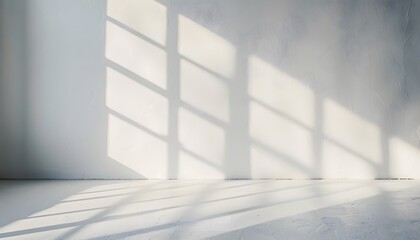 Obraz premium A bright white room with light shining through the window, casting soft shadows on an empty wall. creating an abstract and minimalist background for product display or presentation
