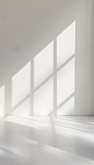 Fototapeta premium A bright white room with light shining through the window, casting soft shadows on an empty wall. creating an abstract and minimalist background for product display or presentation