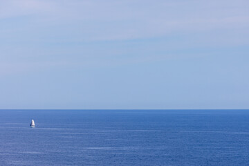 Obraz premium Photo of a sail boat out in the ocean on a clear blue sky day taken in the city of Benidorm in Spain on a sunny day in the summer time