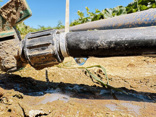 Water dripping from a faulty irrigation pump connection