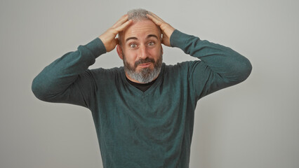 A perplexed caucasian man with a beard, touches his head against a white background, conveying confusion or surprise.
