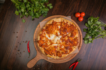 khachapuri with sulguni cheese, herbs and egg on a wooden surface. Georgian pie. Georgian pizza
