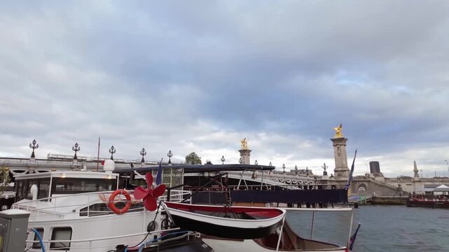 Hanging traditional rowing lifeboat on a ship on the River Seine with the Pont Alexandre III bridge in the background in Paris, France.