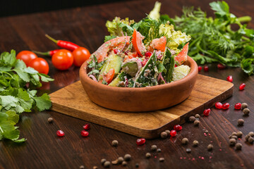Georgian Tbilisi style salad with tomatoes, cucumbers and meat on a wooden table