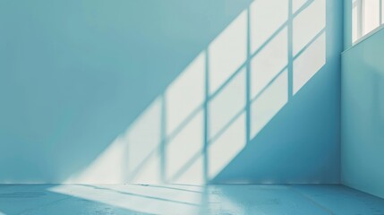 Sunlight streams through large windows onto a serene blue wall, casting intricate shadows and creating a peaceful, minimalist ambiance in an empty room.
