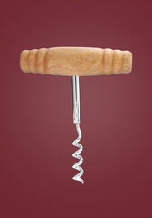 Corkscrew with wooden handle on red background