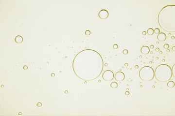 Golden cosmetic oil with bubbles, closeup view