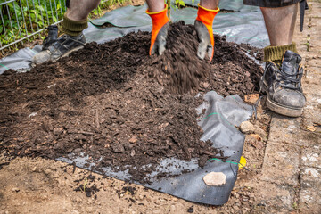 Installing weed control fabric material and bark mulch in a residential garden to control weed...