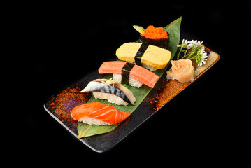 Set of 5 pieces of sushi on a ceramic plate ready to eat.