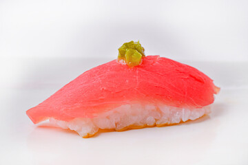 Tuna sushi topped with large, beautiful pieces of wasabi, ready to eat.
