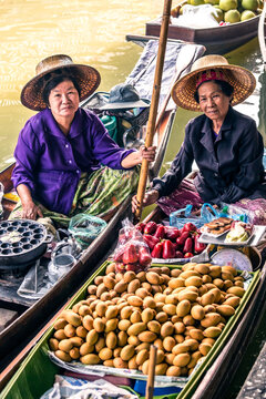 Two thai women on a boat at Damnoen Saduak floating market, Bangkok, Thailand
