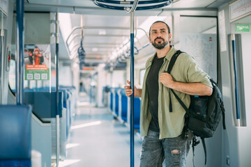 A Caucasian man rides on the train, in the skytrain, in the subway. Urban transport.