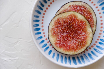 Beautiful fresh sliced black figs on white background