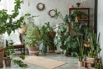A fragment of the interior with a variety of indoor plants and plaster sculptures. Urban jungle...