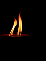Two yellow Candle Flames burn on Black Background. Candle light burning at night isolated black. The warm, flickering light emitted by the candles, creating a serene and contemplative atmosphere.