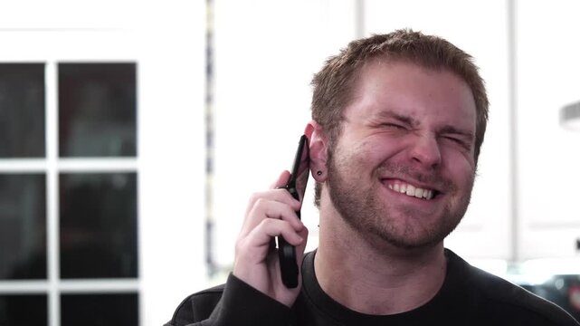 Man makes a call and laughs using a flip phone in slow motion