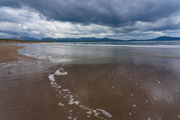 Grey skies pass over Llanddwyn beach on a dark and dismal spring day.