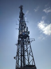 A tall telecommunication tower is strikingly visible with a clear sky as the background