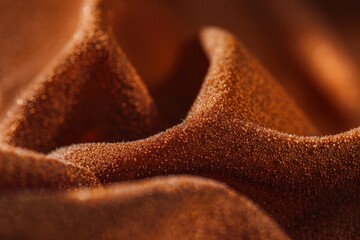 Extreme close-up of sandpaper's rough surface, showcasing its coarse grainy texture. The macro photography highlights every detail of the abrasive material.