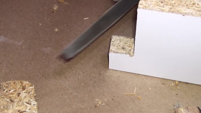 Close up view of rasping a wooden board with a manual rasp.