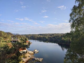 Fototapeta premium Enjoy a picturesque view of a serene lake landscape with clear blue skies and lush greenery
