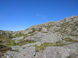 Experience the peaceful beauty of a mountain landscape under a clear blue sky with rugged terrain