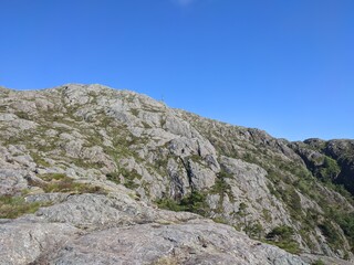 Experience the peaceful beauty of a mountain landscape under a clear blue sky with rugged terrain