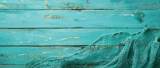 A turquoise wooden wall adorned with a fishing net, evoking a coastal ambiance and reminiscence of maritime adventures.
