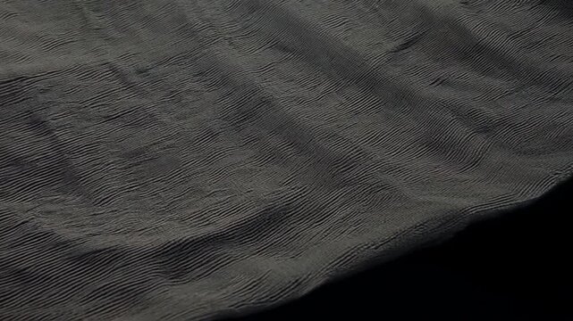 Solid charcoal tweed fabric flowing on black background, symbolizing elegance and sophistication, simulation