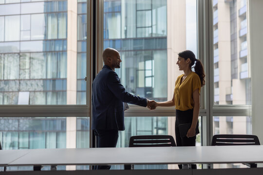 Business persons handshake in a modern office with views of buildings