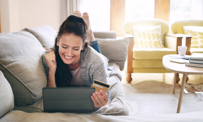 Woman, home and fist pump on tablet with debit card on sofa for online shopping, payment and saving plan. Buying, excited and happy for success on internet banking with rewards, points and approval