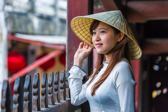 Young asian woman with Ao Dai dress at japanese bridge, Hoi An, Vietnam