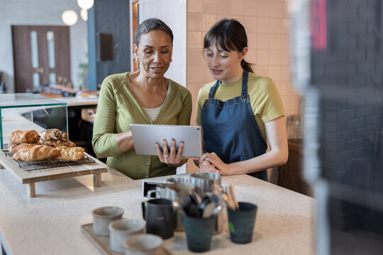 Cafe business owner training an employee 