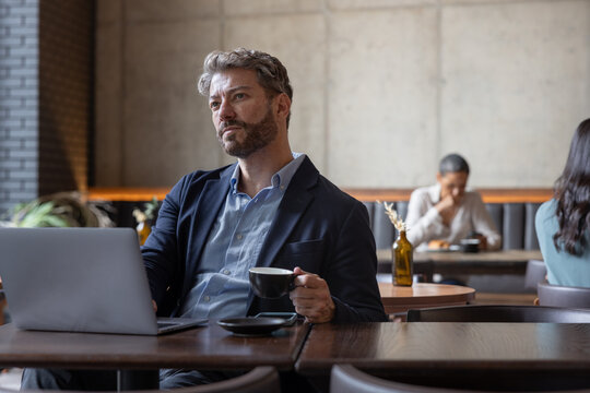 Mature hispanic male businessman working from a cafe