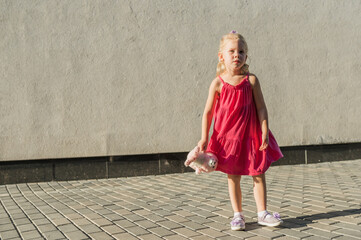 Child girl walks and have fun outdoor with cochlear implant on the head. Hearing aid and treatment concept. Copy space. Inclusion and people with disability