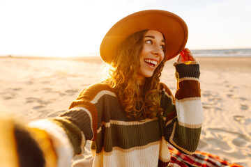 Young woman do selfie shot on mobile cell phone outdoors at sunrise sun dawn over sea background....