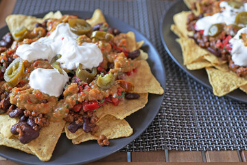 Mexican corn nacho spicy chips served with melted cheese, peppers, tomatoes and salsa