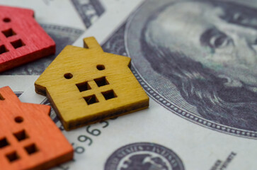 A house set against a backdrop of banknotes represents the financial considerations and investment...