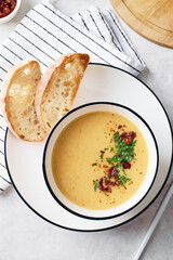 Bowl of potato soup with parsley and bacon with toasted bread croutons in white bowl. Comfort meal