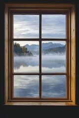 A window in a serene lakeside cabin, capturing a misty morning view with calm waters and distant mountains.