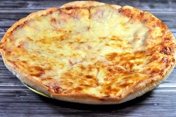 Pizza Margherita, a typical Neapolitan pizza, roundish in shape with a raised edge (the cornicione) and garnished with hand-crushed peeled tomatoes, mozzarella (buffalo mozzarella or fior di latte)