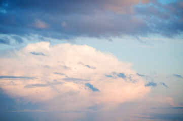 Obraz premium Blue sky background with white dramatic colorful clouds and soft sunlight