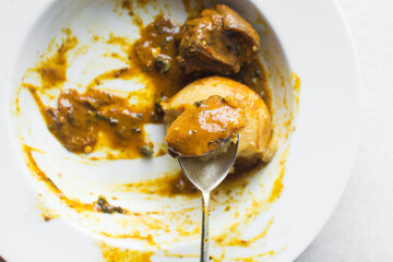 Overhead view of nigerian ogbono soup and eba on a white plate, top view of ogbono draw soup with garri and assorted meats in a soup plate, flatlay of nigerian ogbono and okra soup