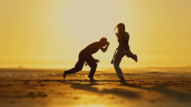 A flexible woman has training martial arts - a capoeira on sunset