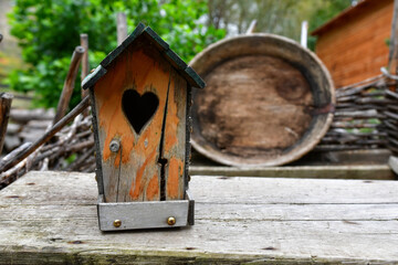 Charming Wooden Birdhouse With Heart-Shaped Opening Amidst a Rustic Outdoor Setting in Spring