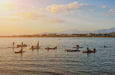 People are busy with Standup paddleboarding against the backdrop of the city of Side in Turkey.
